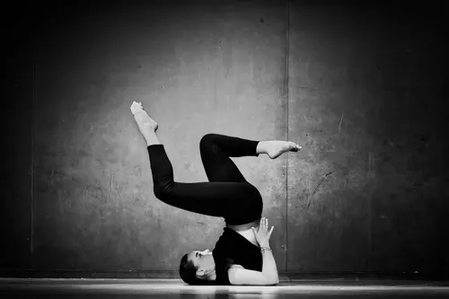 une femme qui fait un handstant dans un studio de danse